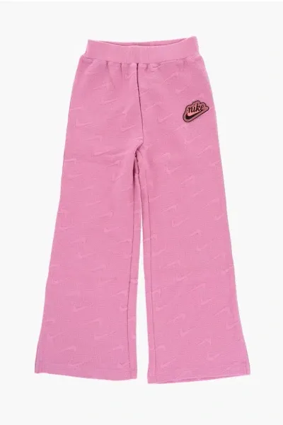 Nike Solid Color Flared Pants With All-over Logo In Pink