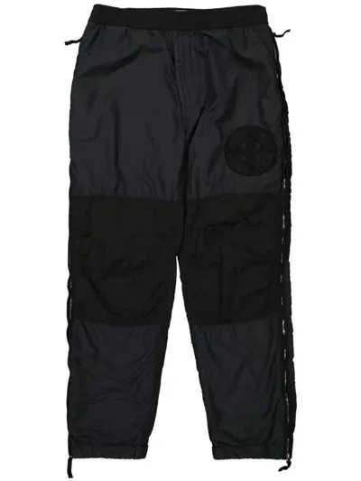 Stone Island Logo-patch Creased Tapered Trousers In Black